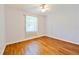 Bright bedroom features hardwood floors, a ceiling fan, and a sun-lit window at 8315 Raoul Ave, North Port, FL 34291