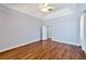 Inviting bedroom with hardwood floors, a ceiling fan, and an open doorway to another room at 8315 Raoul Ave, North Port, FL 34291