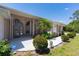 Charming home featuring a columned entryway, arched windows, lush landscaping, and manicured shrubbery at 8315 Raoul Ave, North Port, FL 34291