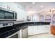 Modern kitchen featuring white cabinets, granite countertops, and stainless steel appliances at 8315 Raoul Ave, North Port, FL 34291