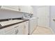 Well-lit laundry room with white cabinets, countertop, sink, and modern washer and dryer at 8315 Raoul Ave, North Port, FL 34291