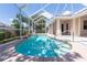 A screened-in pool with clear blue water and a view of the backyard and white patio area at 8315 Raoul Ave, North Port, FL 34291