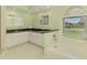 Light green bathroom with dual sinks, tile floors, and a bathtub at 452 Greenwich Nw Ave, Port Charlotte, FL 33952
