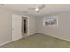 A brightly lit bedroom features a ceiling fan, neutral walls, carpeted floor and a window to the outdoors at 452 Greenwich Nw Ave, Port Charlotte, FL 33952