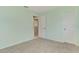 A bright bedroom featuring neutral walls and carpet with access to another room through a white door at 452 Greenwich Nw Ave, Port Charlotte, FL 33952