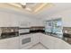 Modern kitchen featuring white cabinets and black counters, with views of the pool at 452 Greenwich Nw Ave, Port Charlotte, FL 33952