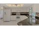 Bright kitchen featuring white appliances and cabinets, accented by a tile backsplash and dark countertop at 452 Greenwich Nw Ave, Port Charlotte, FL 33952