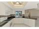 Modern kitchen with white cabinets, black counters, and a view of the pool area at 452 Greenwich Nw Ave, Port Charlotte, FL 33952