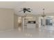 Open-concept living room with tile flooring, ceiling fan, and views into the kitchen and lanai at 452 Greenwich Nw Ave, Port Charlotte, FL 33952
