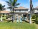Backyard view showcasing the screened pool, spa, lush landscaping, and tranquil waterfront at 11663 Anhinga Ave, Venice, FL 34292