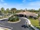 Aerial view of community clubhouse with beautiful landscaping, palm trees, and tennis courts at 11663 Anhinga Ave, Venice, FL 34292