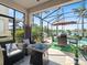 Relaxing screened-in patio with stylish seating, grill, and fire pit overlooking a serene lake at 11663 Anhinga Ave, Venice, FL 34292