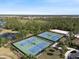 Aerial view showcasing the community's well-maintained tennis courts surrounded by trees at 11663 Anhinga Ave, Venice, FL 34292
