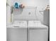 Laundry room featuring a white washer and dryer with overhead storage shelves at 14204 Heritage Landing Blvd # 712, Punta Gorda, FL 33955
