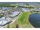 An aerial view of the community featuring a clubhouse, pool, tennis courts, a golf course, and a lake at 14413 Heritage Landing Blvd, Punta Gorda, FL 33955