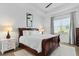 Well-lit bedroom with a dark wood sleigh bed, light walls, and a large window with bright natural light at 14413 Heritage Landing Blvd, Punta Gorda, FL 33955