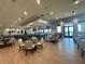 Open dining area with a large bar, many tables and seating, TVs, wood-look floors, and plenty of lighting at 14413 Heritage Landing Blvd, Punta Gorda, FL 33955