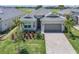 Beautiful single-story home with a two-car garage, landscaped yard, and golf course views in the background at 14413 Heritage Landing Blvd, Punta Gorda, FL 33955