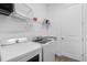 Bright laundry room with a front loading washer and dryer, sink, cabinets and wire shelving at 14413 Heritage Landing Blvd, Punta Gorda, FL 33955