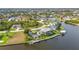Overhead view captures a home with a pool and dock, surrounded by lush greenery on a waterfront property at 15490 Seafoam Cir, Port Charlotte, FL 33981