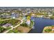 Aerial view of a waterfront home with a private dock on a tranquil canal, surrounded by lush landscaping at 15490 Seafoam Cir, Port Charlotte, FL 33981