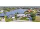 Waterfront home boasts lush landscaping, a private dock, and serene water views from an aerial perspective at 15490 Seafoam Cir, Port Charlotte, FL 33981