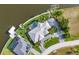 An aerial perspective highlights a home with a pool, circular driveway, and private dock along a canal at 15490 Seafoam Cir, Port Charlotte, FL 33981