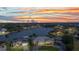 Stunning aerial view of a waterfront home with lush landscaping and a picturesque sunset backdrop at 15490 Seafoam Cir, Port Charlotte, FL 33981