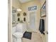 Bathroom features a vanity, a toilet and a door for natural light at 15490 Seafoam Cir, Port Charlotte, FL 33981