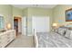 Bedroom features a dresser with an open doorway to a bathroom and double door closet at 15490 Seafoam Cir, Port Charlotte, FL 33981