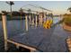 A well-kept boat dock with a lift and space for seating offers waterfront access for homeowners at 15490 Seafoam Cir, Port Charlotte, FL 33981