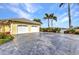 Spacious two-car garage with a decorative driveway and lush landscaping at 15490 Seafoam Cir, Port Charlotte, FL 33981