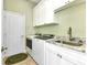 Laundry room with washer, dryer, sink, granite countertop, and ample cabinet storage at 15490 Seafoam Cir, Port Charlotte, FL 33981