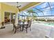 Covered patio with dining set overlooking a pool and waterfront view at 15490 Seafoam Cir, Port Charlotte, FL 33981