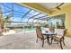 Covered patio with dining set overlooking a pool and waterfront view at 15490 Seafoam Cir, Port Charlotte, FL 33981