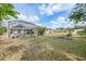 Spacious backyard featuring a screened-in pool enclosure, lush greenery, and a beautiful blue sky at 1556 Eagle St, Port Charlotte, FL 33952