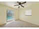 Light-filled bedroom with a ceiling fan, carpeted floor and sliding door access to the pool area at 1556 Eagle St, Port Charlotte, FL 33952