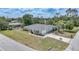 A meticulously maintained residence featuring verdant landscaping, an attached garage, and a long concrete driveway at 1556 Eagle St, Port Charlotte, FL 33952