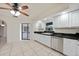Charming kitchen with white cabinetry, black countertops, stainless steel dishwasher, and tiled flooring at 1556 Eagle St, Port Charlotte, FL 33952