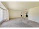 Bright living room featuring neutral carpeting and large windows with curtains at 1556 Eagle St, Port Charlotte, FL 33952