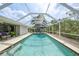 Well-maintained pool area with a screened enclosure, surrounded by lush greenery and ample deck space at 1556 Eagle St, Port Charlotte, FL 33952