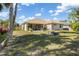 Backyard features a stone firepit, lush green lawn, and screened-in patio at 16450 Bauers Ave, Port Charlotte, FL 33954