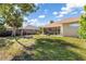 Backyard features a lush green lawn, stone firepit, and screened-in patio at 16450 Bauers Ave, Port Charlotte, FL 33954