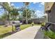 Spacious backyard with a grill, stone firepit, lush green lawn and patio furniture at 16450 Bauers Ave, Port Charlotte, FL 33954