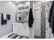 Bright bathroom with dual vanities, framed mirrors, modern fixtures, and a stand-up shower with mosaic accent at 16450 Bauers Ave, Port Charlotte, FL 33954