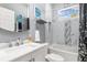 Bright bathroom with a single vanity, tub and shower combination, and a window overlooking the backyard at 16450 Bauers Ave, Port Charlotte, FL 33954