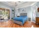 Well-lit bedroom with wood floors, tray ceiling, and sliding door access to outdoor patio at 16450 Bauers Ave, Port Charlotte, FL 33954