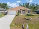 Charming single-story home with a well-manicured lawn, covered entryway, and two-car garage at 16450 Bauers Ave, Port Charlotte, FL 33954