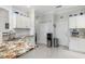 Well-lit kitchen with granite countertops, white cabinetry, and a view of the backyard at 16450 Bauers Ave, Port Charlotte, FL 33954