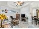 Living room with media center, ceiling fan, neutral tile flooring, and comfortable furnishings at 16450 Bauers Ave, Port Charlotte, FL 33954